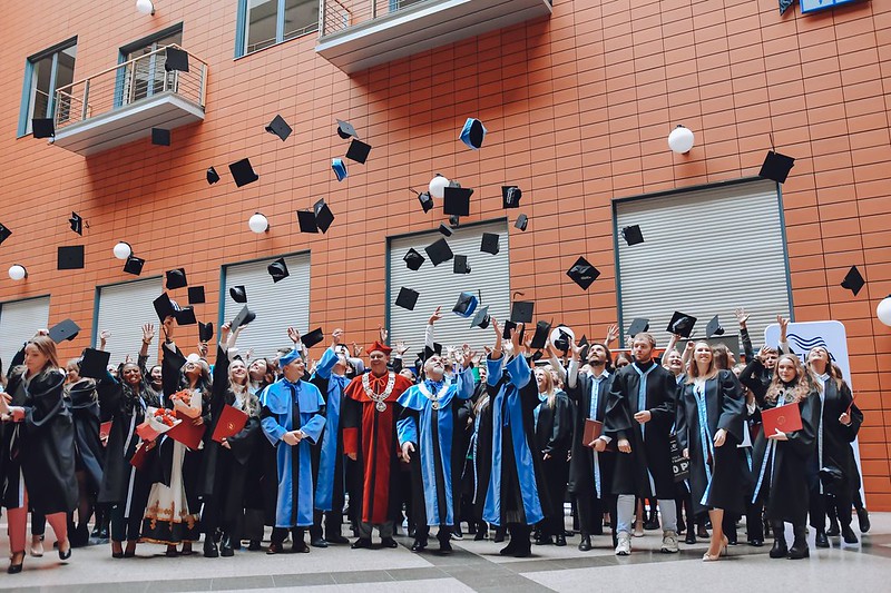 absolwenci WZ 2023 podrzucają birety na patio