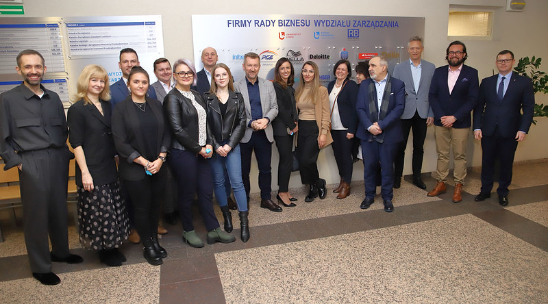 członkowie firm Rady Biznesu i władze Wydziału na wspólnym zdjęciu przed tablicą RB
