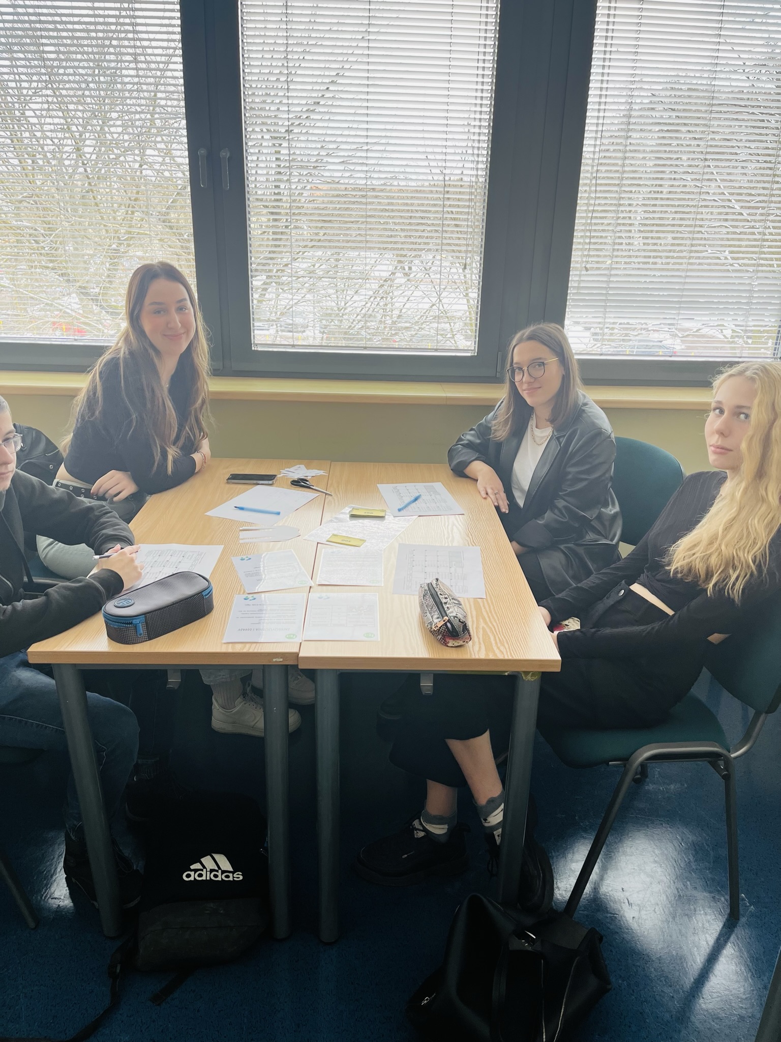 uczennice siedzą w zespole przy ławkach