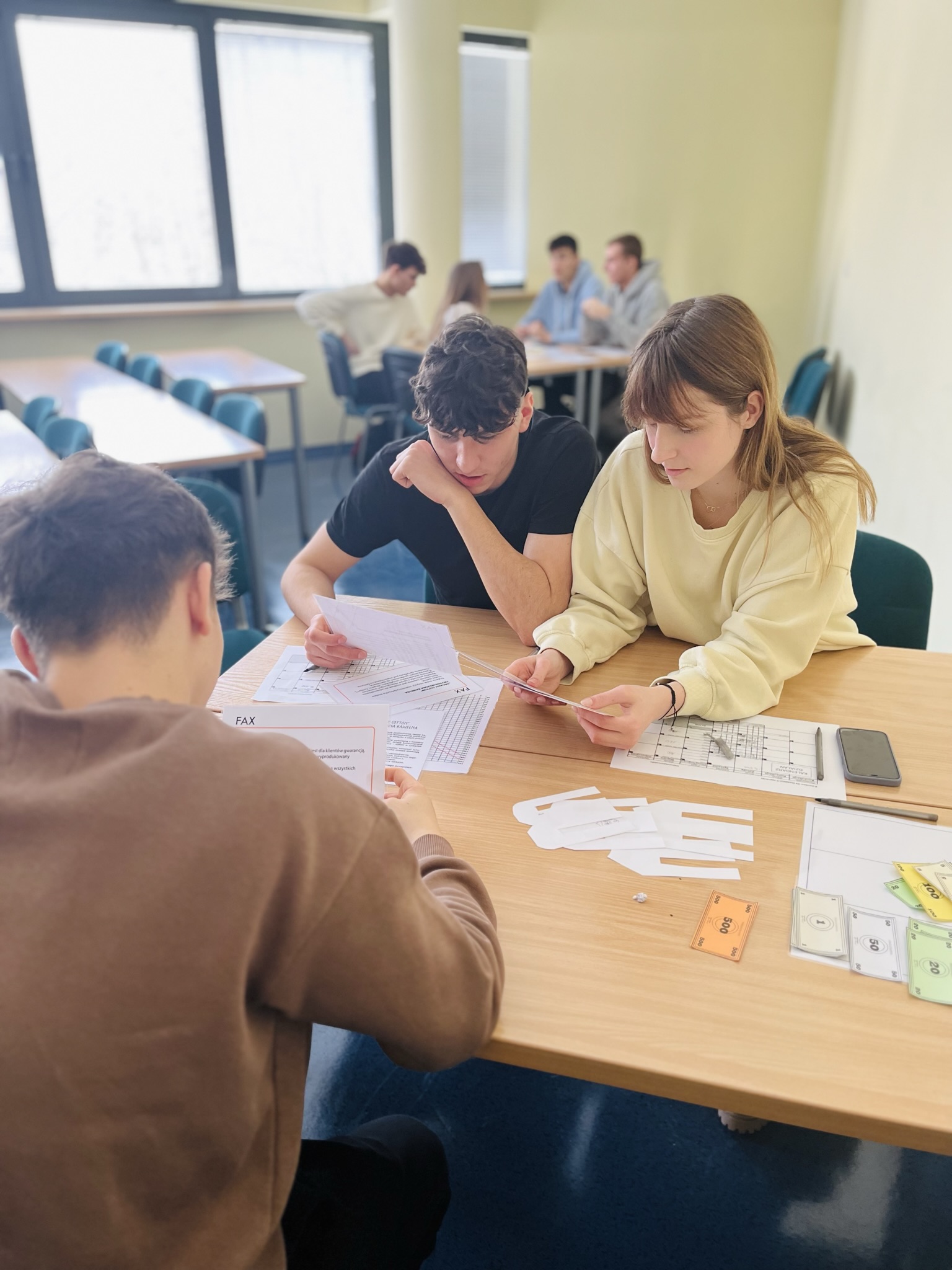 troje uczniów pracuje nad zadaniem