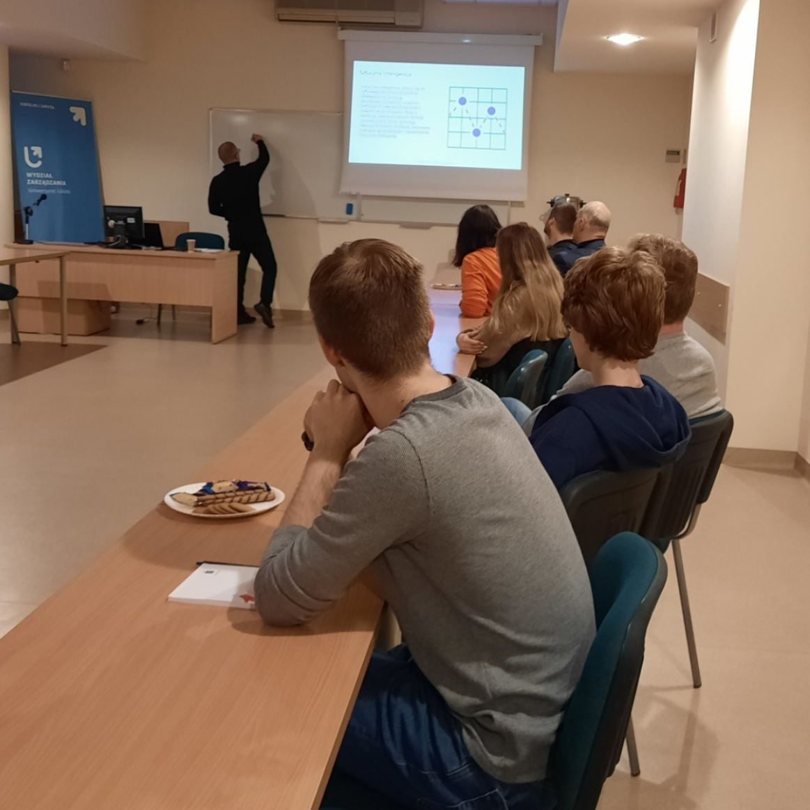 słuchacze wykładu siedzą w ławkach