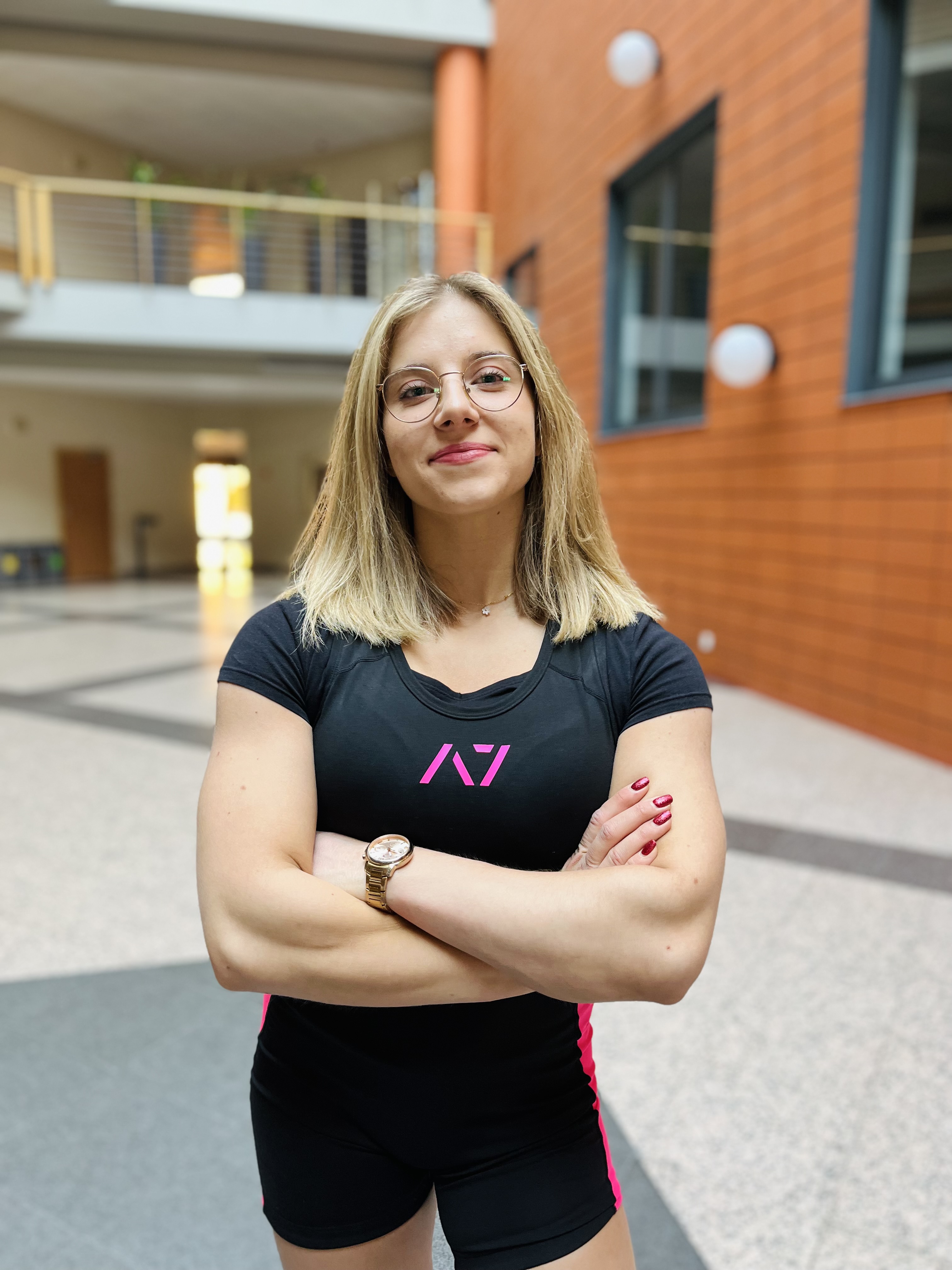 Zdjęcie przedstawia kobietę stojącą na patio wydziału Zarządzania UŁ