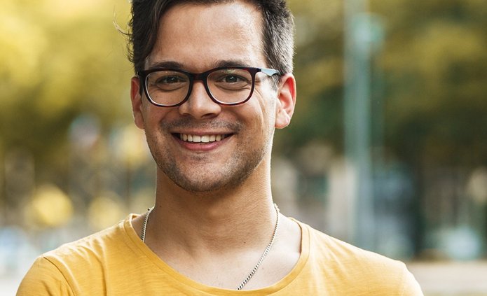 kolorowe zdjęcie przedstawiające młodego mężczyznę trzymającego książki