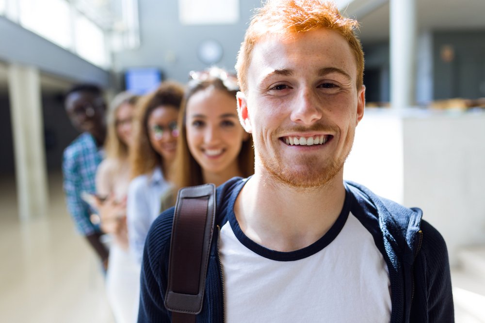 A group of smiling students standing in a row