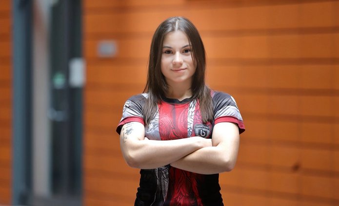 zdjęcie przedstawia młodą kobietę stojącą na patio Wydziału Zarządzania