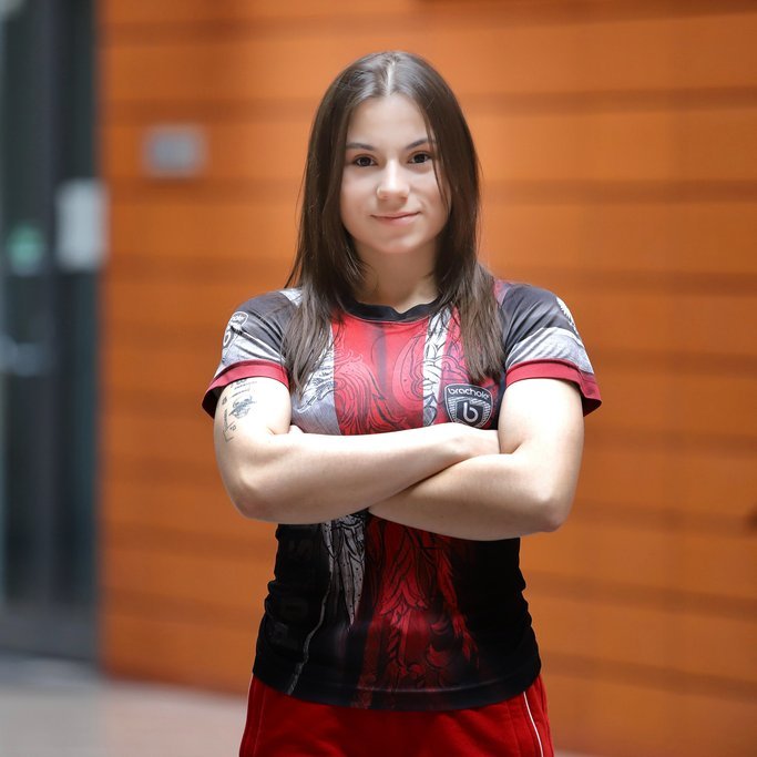 zdjęcie przedstawia młodą kobietę stojącą na patio Wydziału Zarządzania