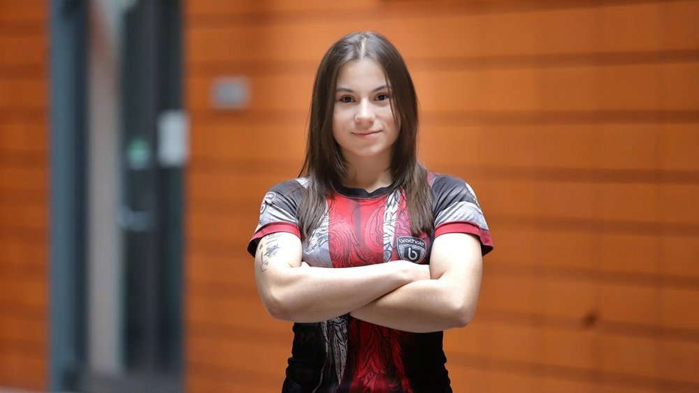 zdjęcie przedstawia młodą kobietę stojącą na patio Wydziału Zarządzania