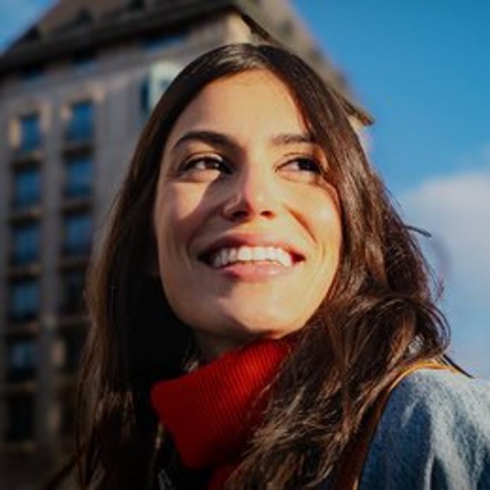 A woman in front of a building and a sign: Are you looking for free training in various fields? Here are the top 5 within the Santander Open Academy
