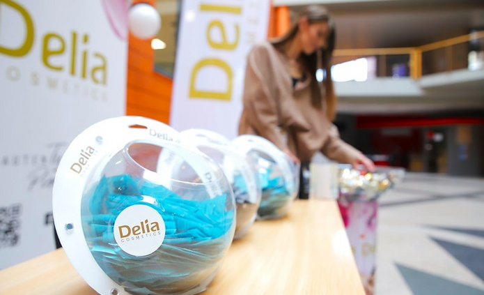 produkty Delii na tle roll-upa