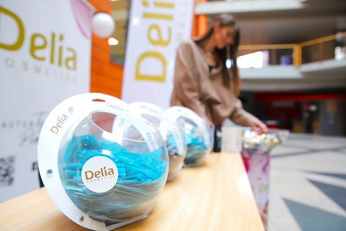 produkty Delii na tle roll-upa