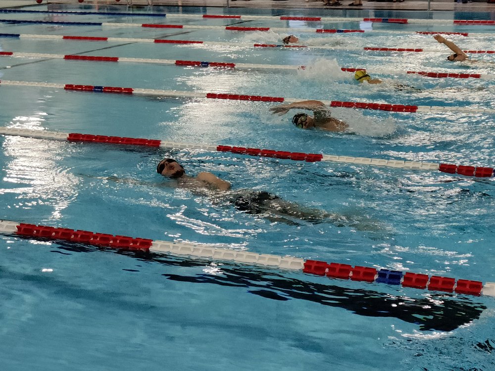 Łukasz Gmaj, student UŁ z sekcji sportowej po torze płynie stylem grzbietowym