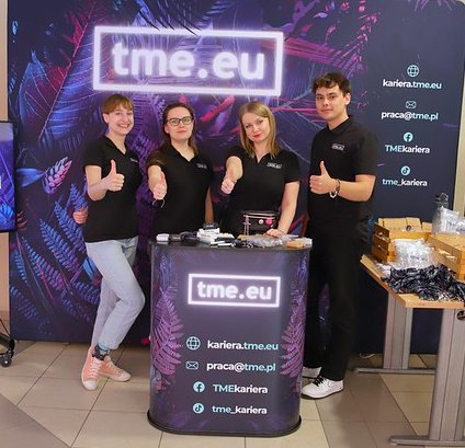 pracownicy TME na tle ścianki