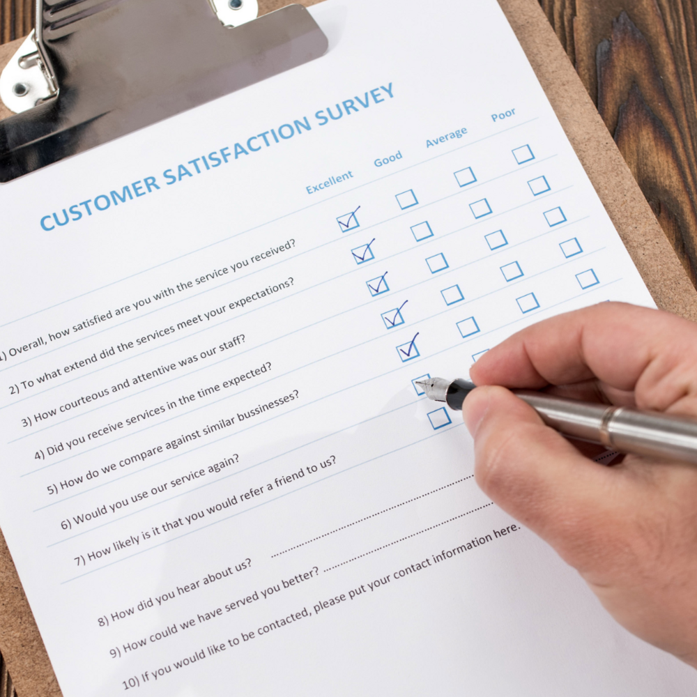 Zdjęcie przedstawia dłoń z długopisem, wypełniającą ankietę