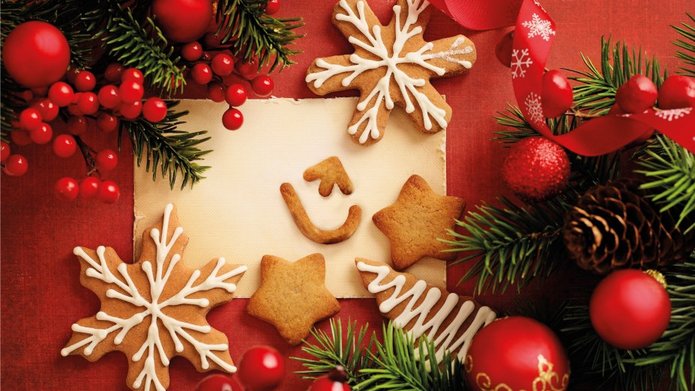 Karta świąteczna z czerwonymi bombkami i ciasteczkami w kształcie gwiazdek i logo UŁ