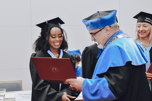 absolwentka odbiera dyplom z rąk Dziekana