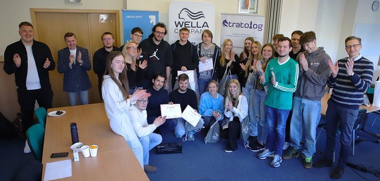 uczestnicy gry na tle roll-upów wydziału i sponsorów