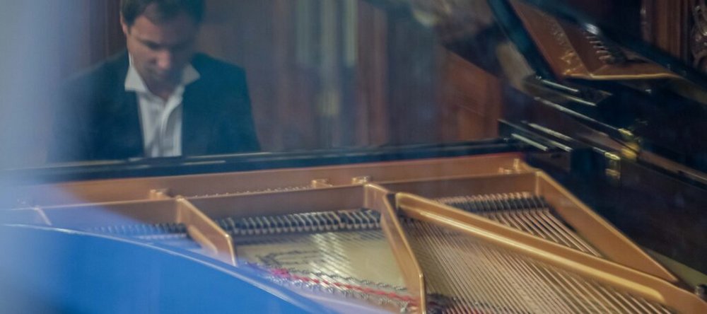 A man wearing a suit at the grand piano