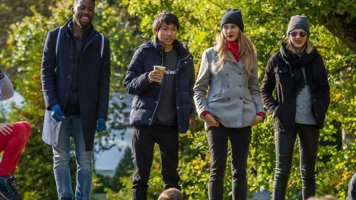 A group of young people against a background of green trees