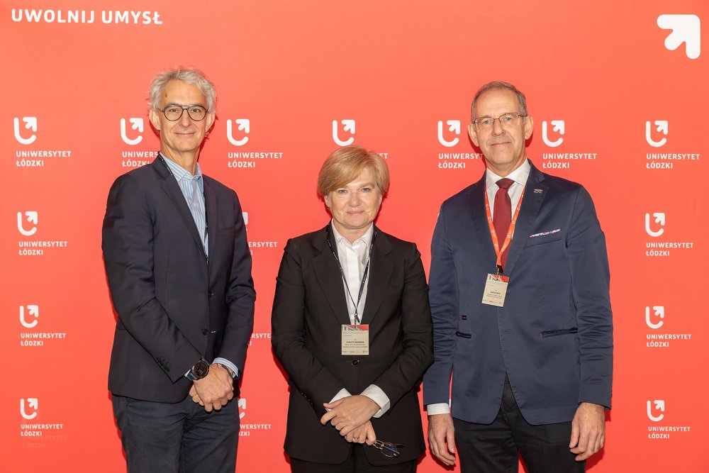 troje naukowców na tle ścianki z logotypami UŁ