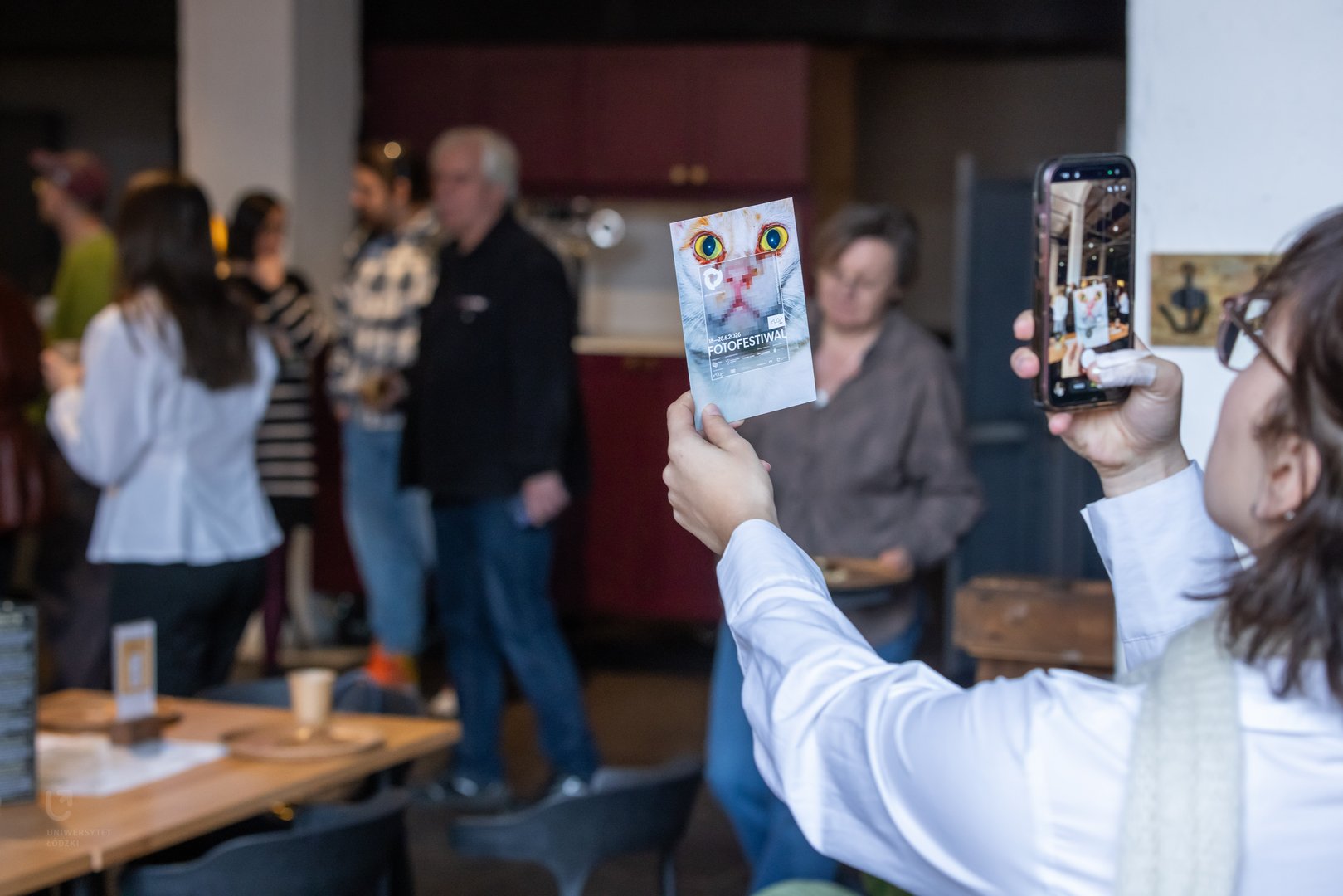 Osoba fotografująca pocztówkę FotoFestiwalu