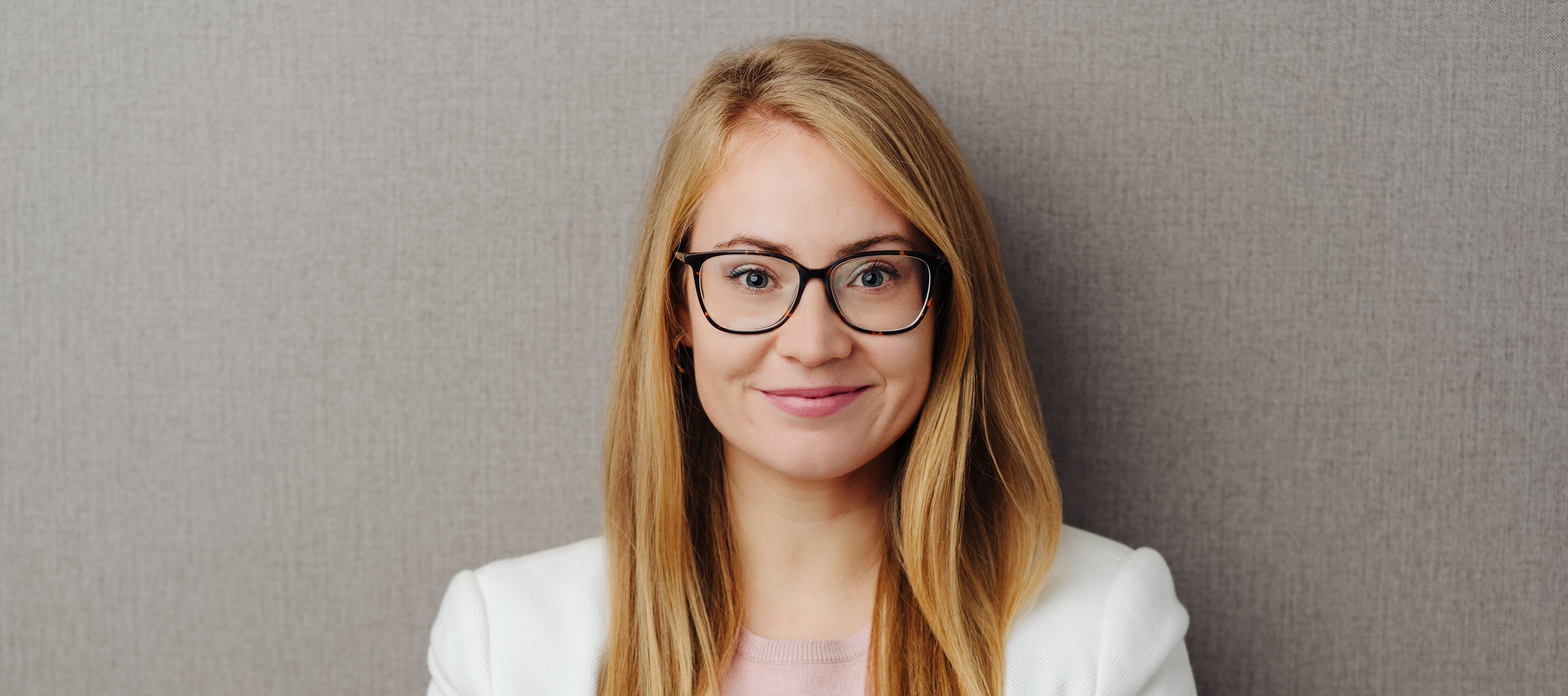 Dziewczyna w okularach na tle ściany