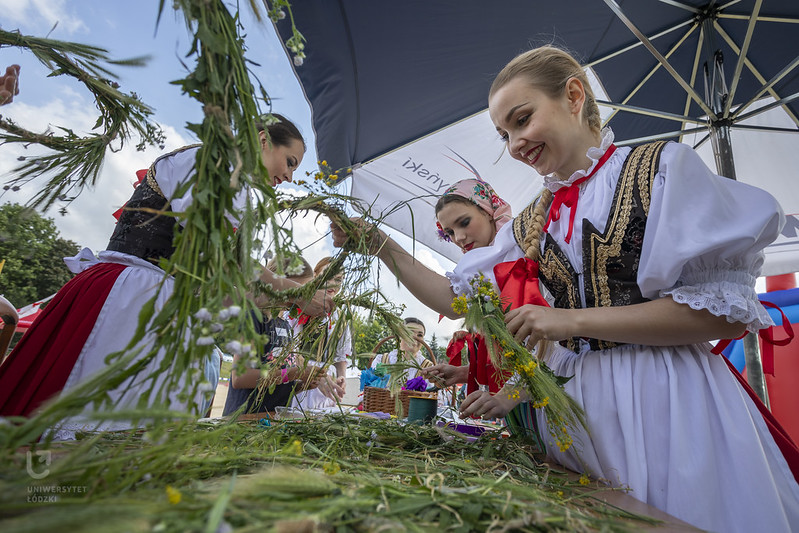 Plecenie wianków przez dziewczyny w strojach ludowych