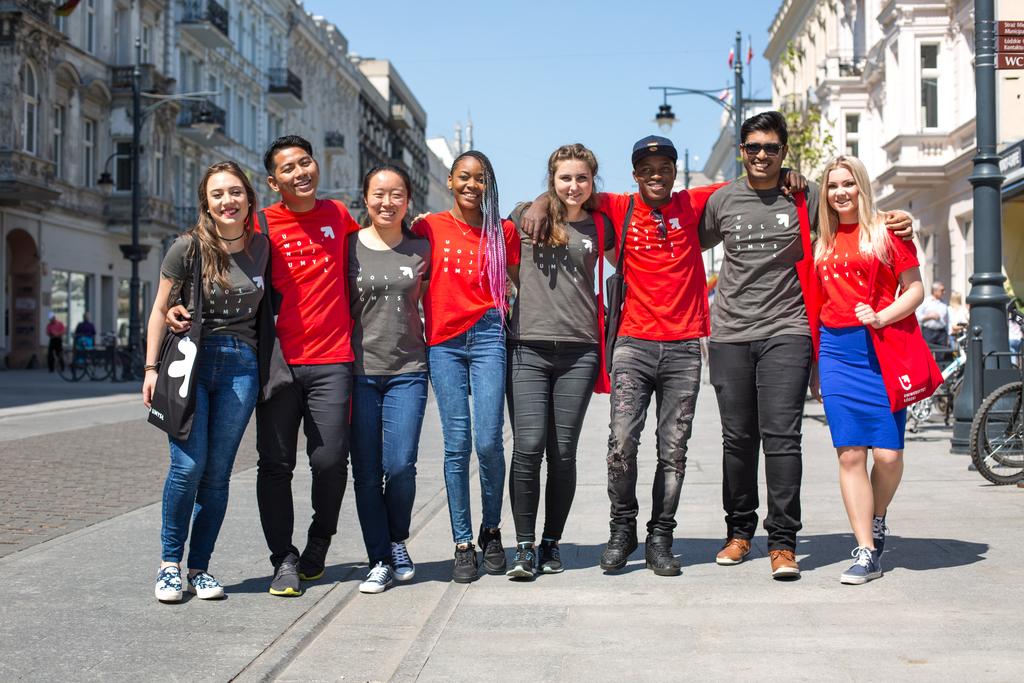 A group of young people of different races standing together on Piotrkowska Street in Lodz